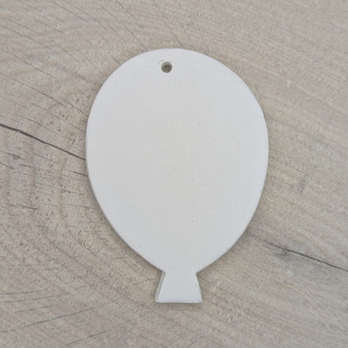 White clay balloon decoration / tag / ornament on wooden background