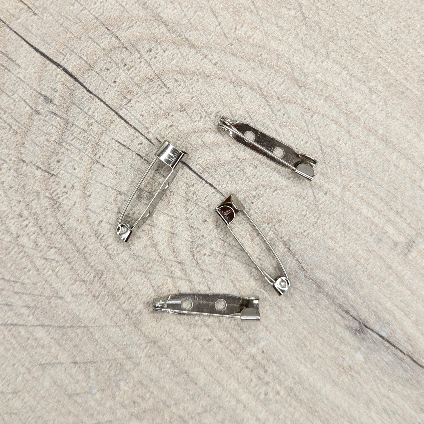 Four metal brooch clips