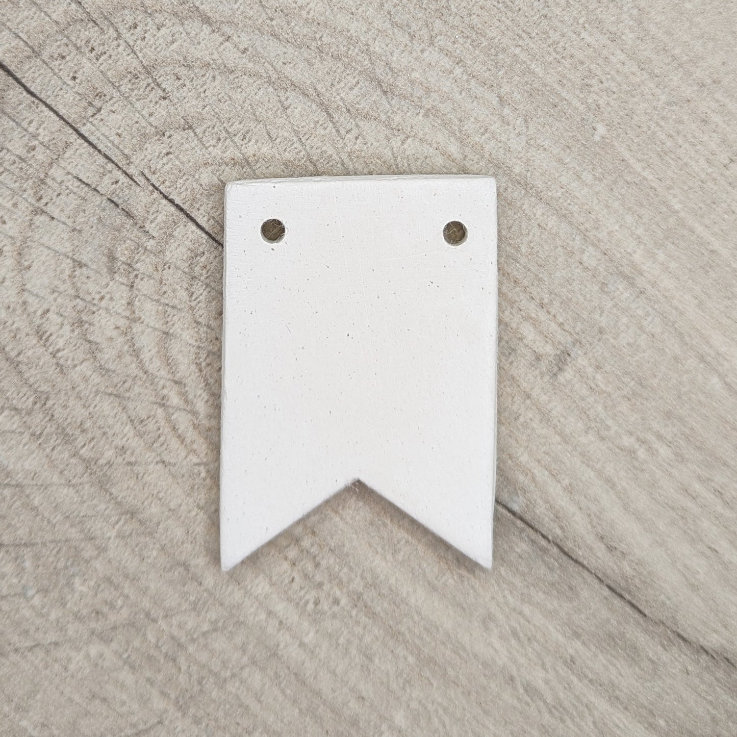 clay decoration in the shape of bunting, two holes on the top edge