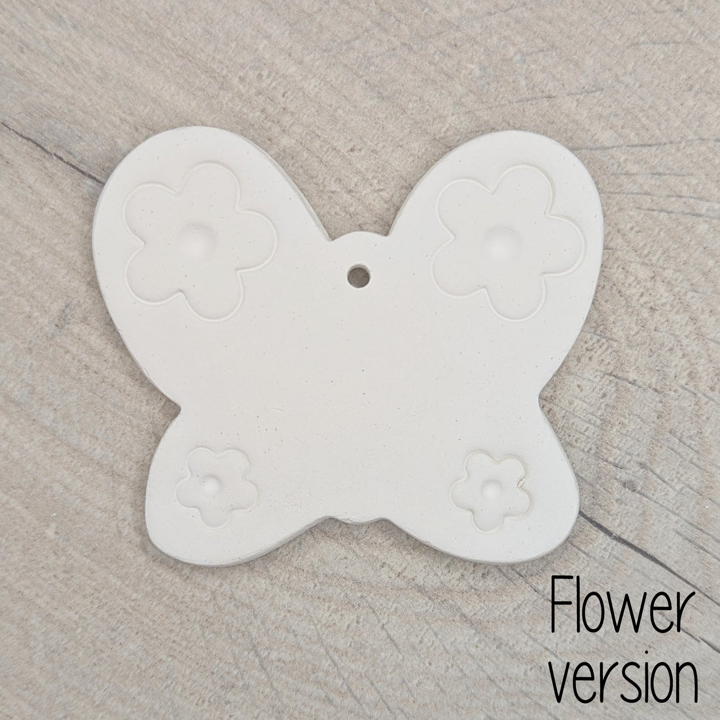 small air dried clay butterfly decoration, with a flower pattern stamped into the wings