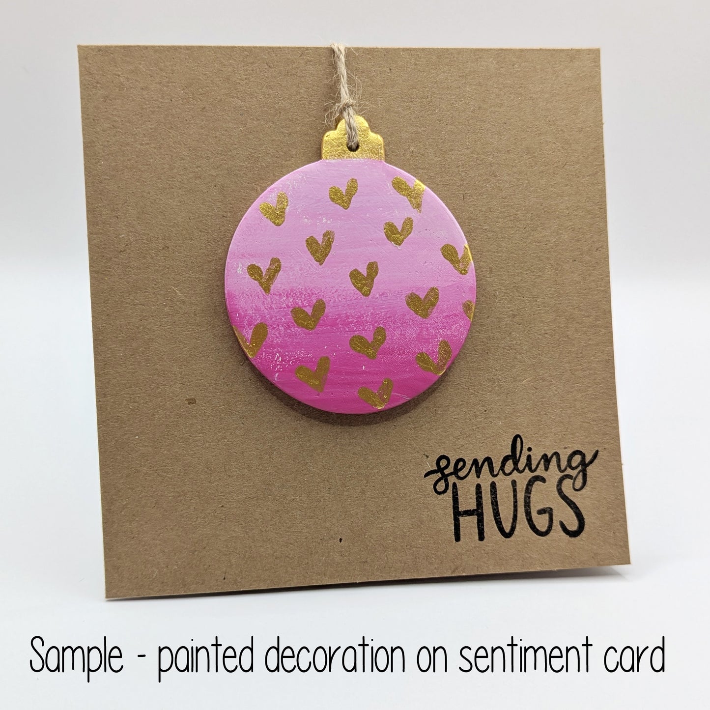 sending hugs card with a pink bauble clay decoration attached to the front, bauble has gold hearts on it