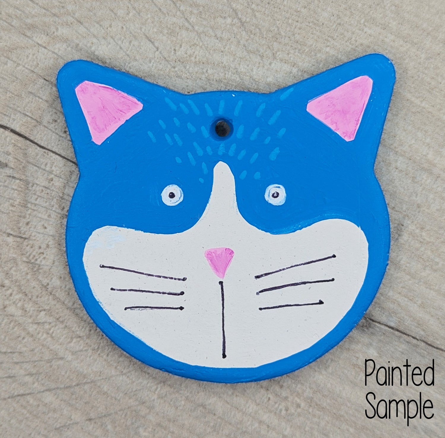 sample of large cat face decoration, painted in bright blue with pink ears and a startled look for cuteness
