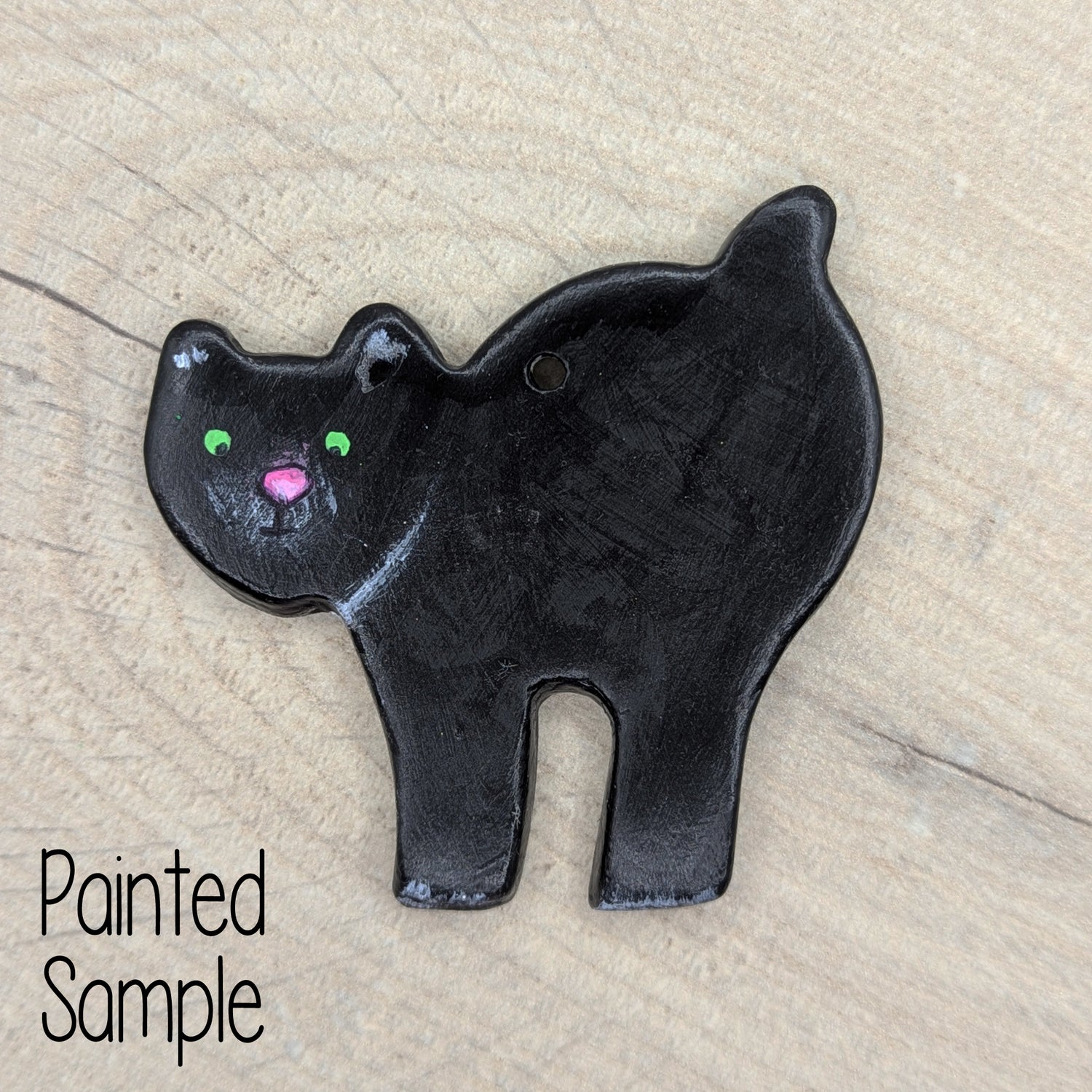 arched back cat clay decoration painted in black like a witches cat with green eyes