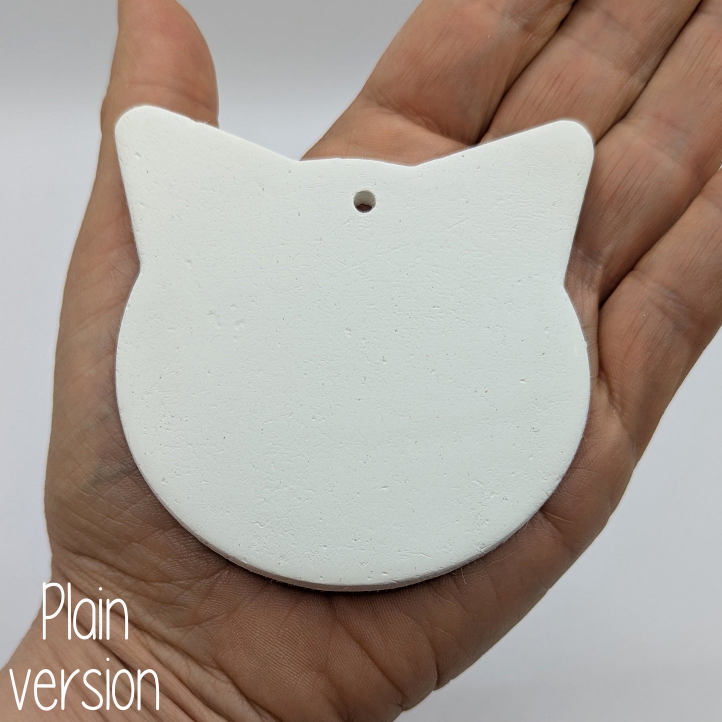 large cat or tiger shaped clay decoration made of air dried clay being held in some ones hand to show size