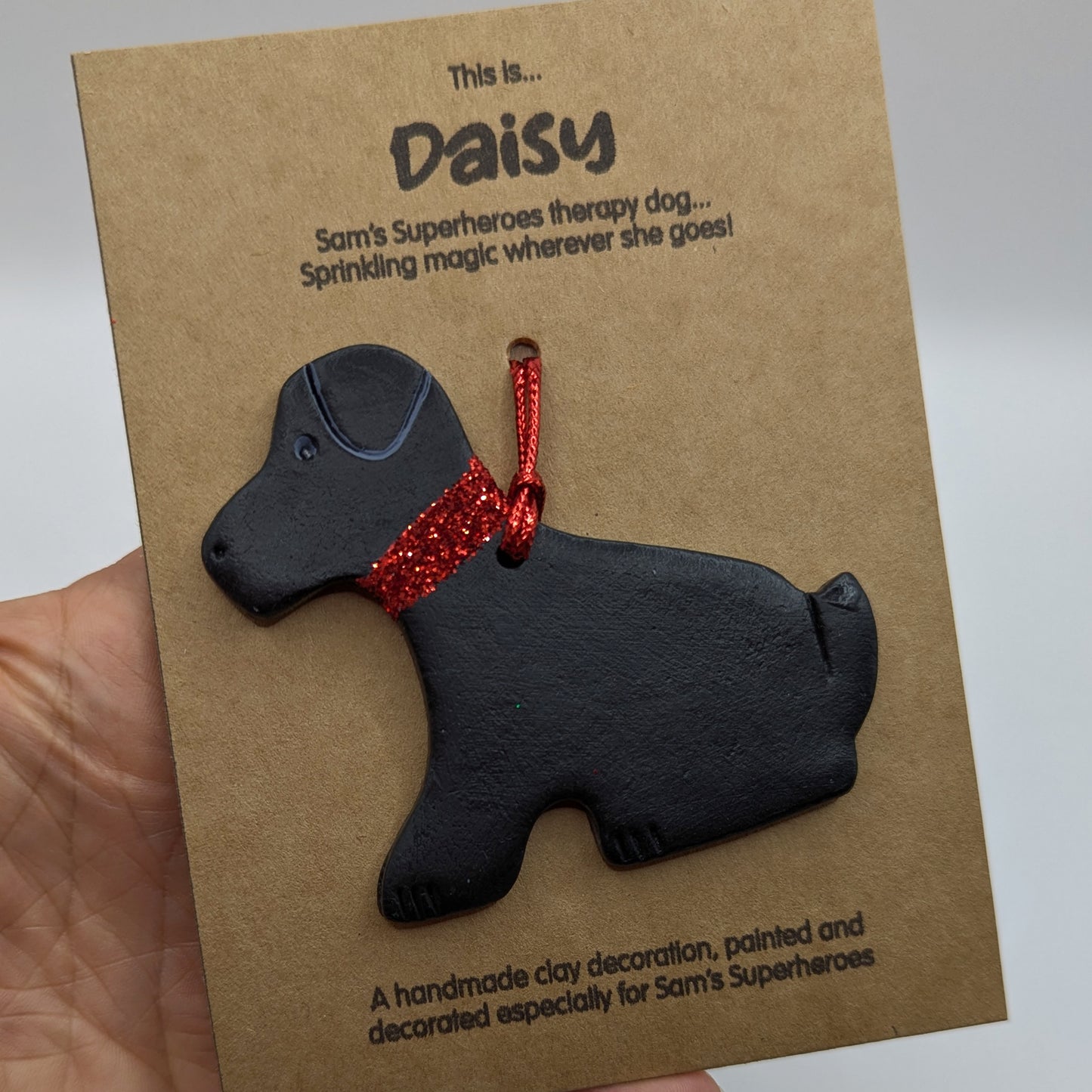 Sam's superheroes black Labrador dog decoration, handmade and painted in black with a red glitter collar to match actual therapy dog daisy