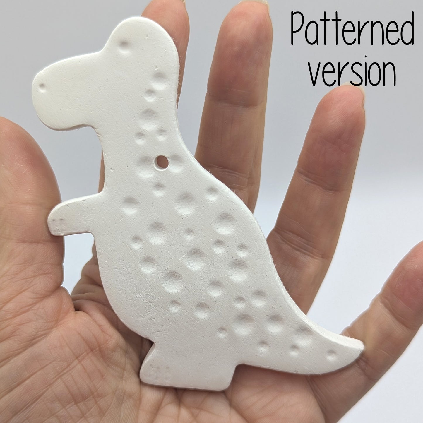 spotted Tyrannosaurus dinosaur clay decoration, in ladies hand for scale