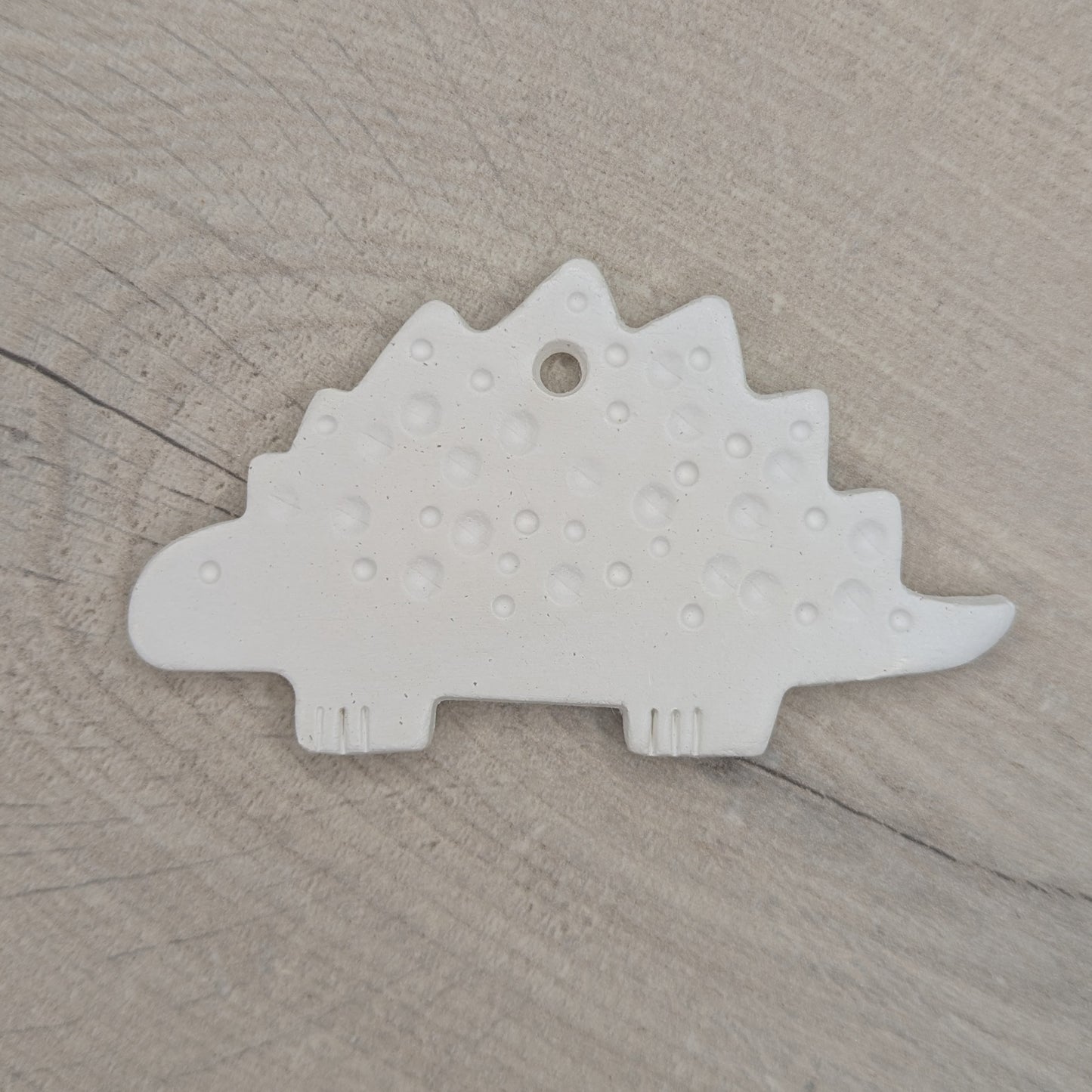 spotted Stegosaurus dinosaur air dried clay decoration, for children and adults to paint at home