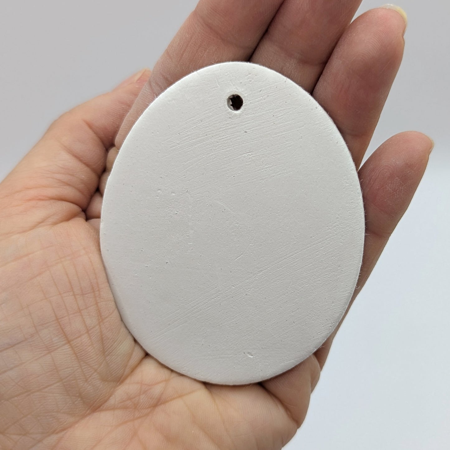 plain easter egg clay decoration in palm of hand
