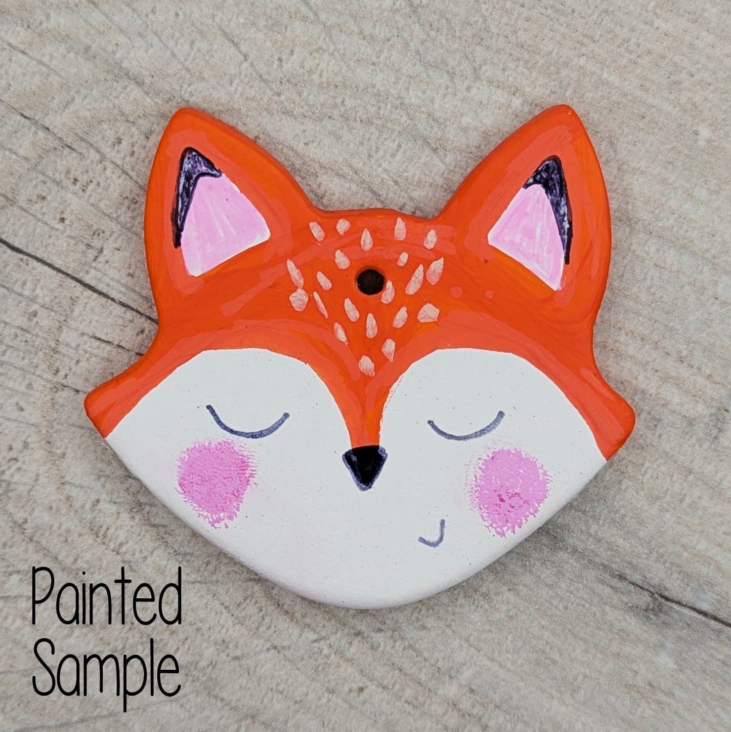 female fox head painted in orange/brown and white acrylic paint with facial features drawn on with sharpie