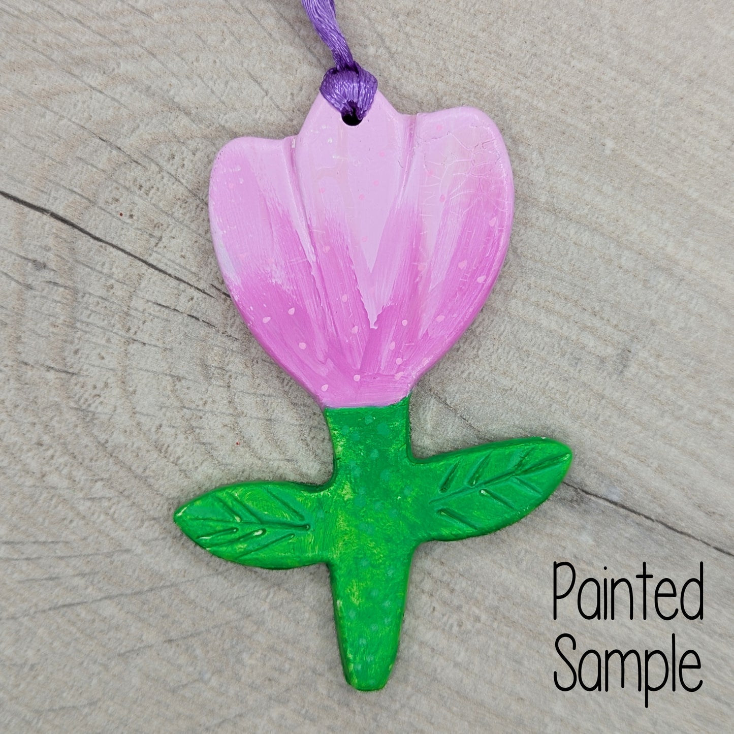 tulip clay decoration painted with pale pink petals and bright green stem and leaves