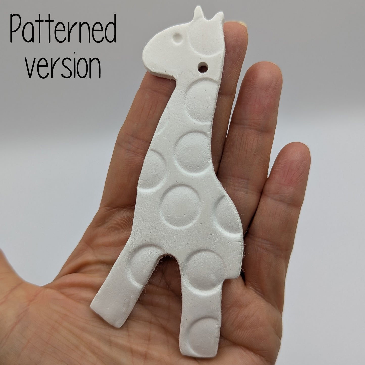 patterned air dried clay giraffe decoration in some ones hand to show size