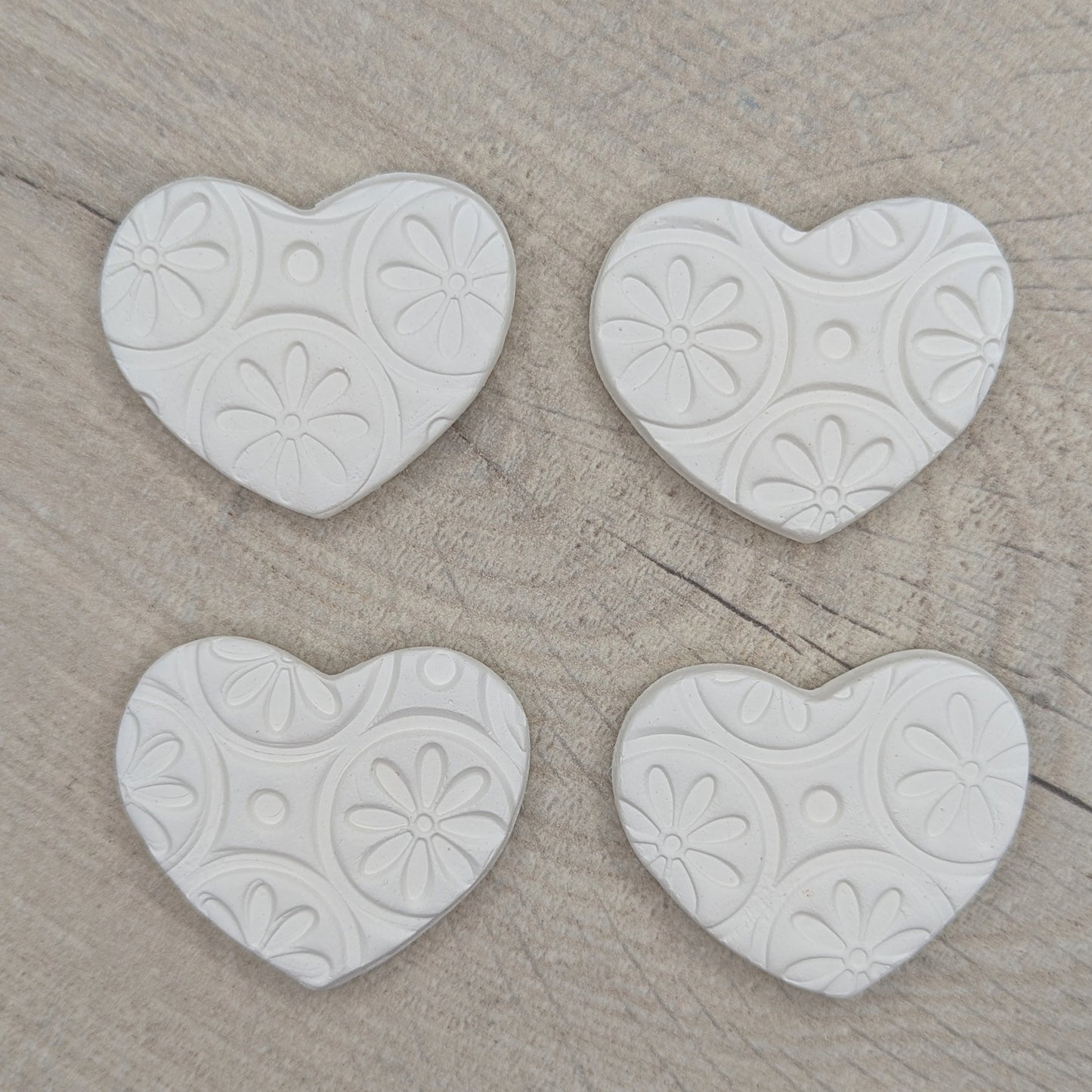 4 small heart clay decorations to show the different pattern layouts on the clay