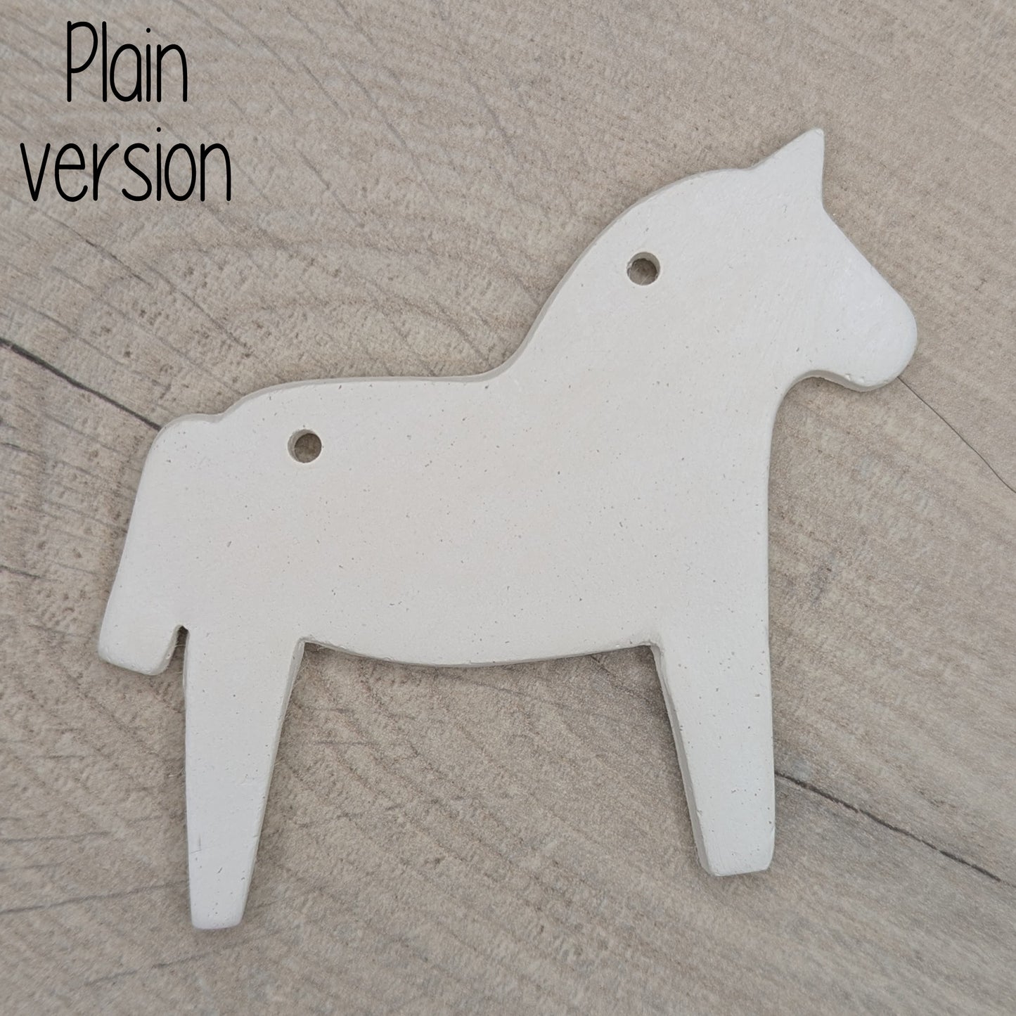 Horse shaped white clay decoration on a wooden surface, plain version