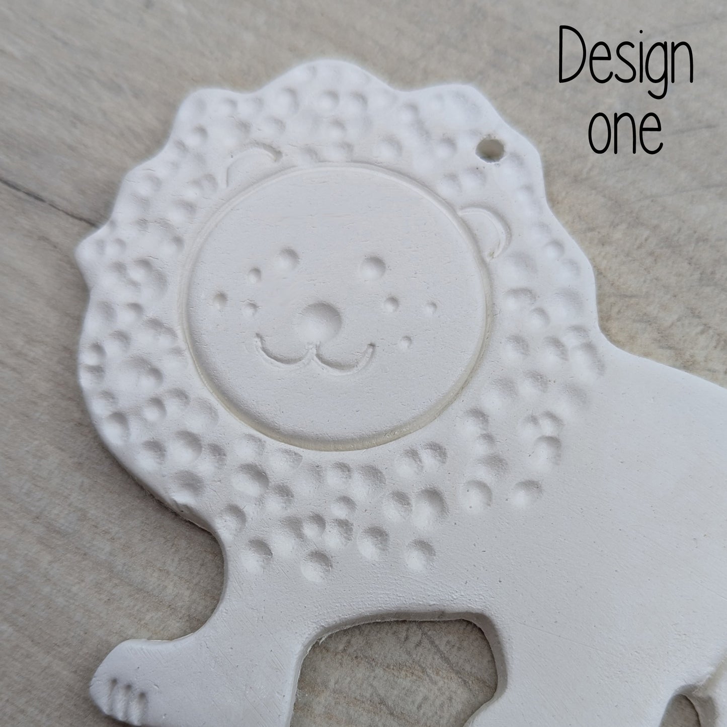 close up of lion air dried clay decoration, with mane and face stamped into the clay