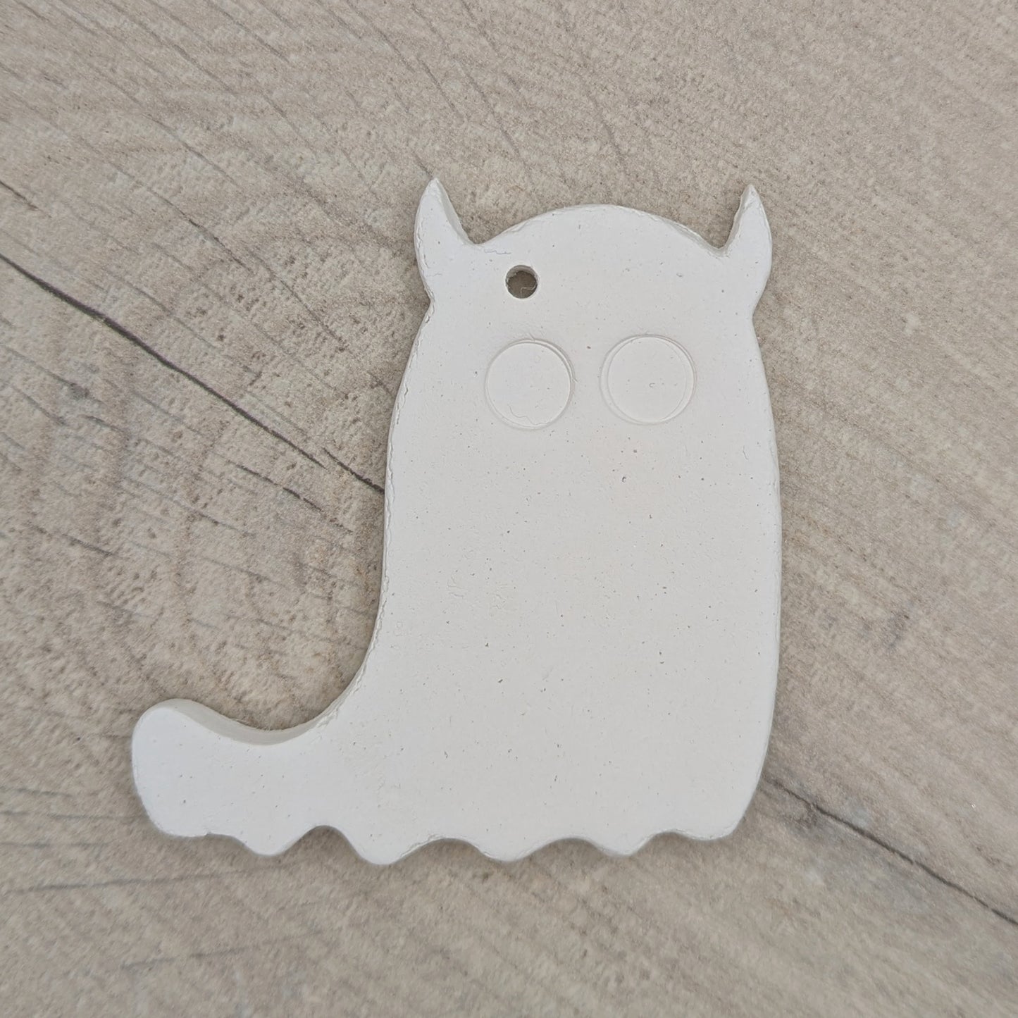 White ghost shaped air dried clay decoration with 2 large eyes