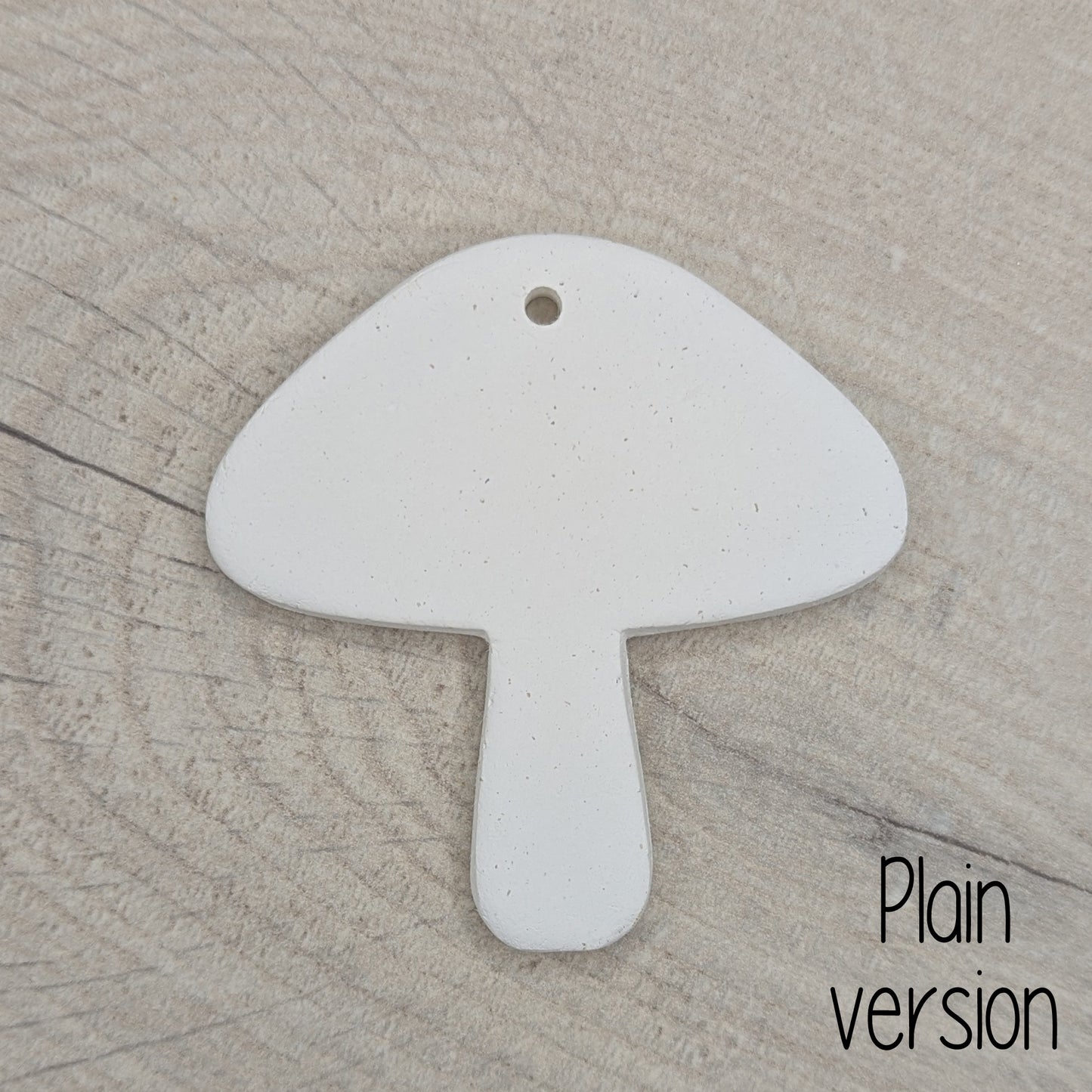 mushroom shaped clay decoration / tag on a wooden surface, plain version