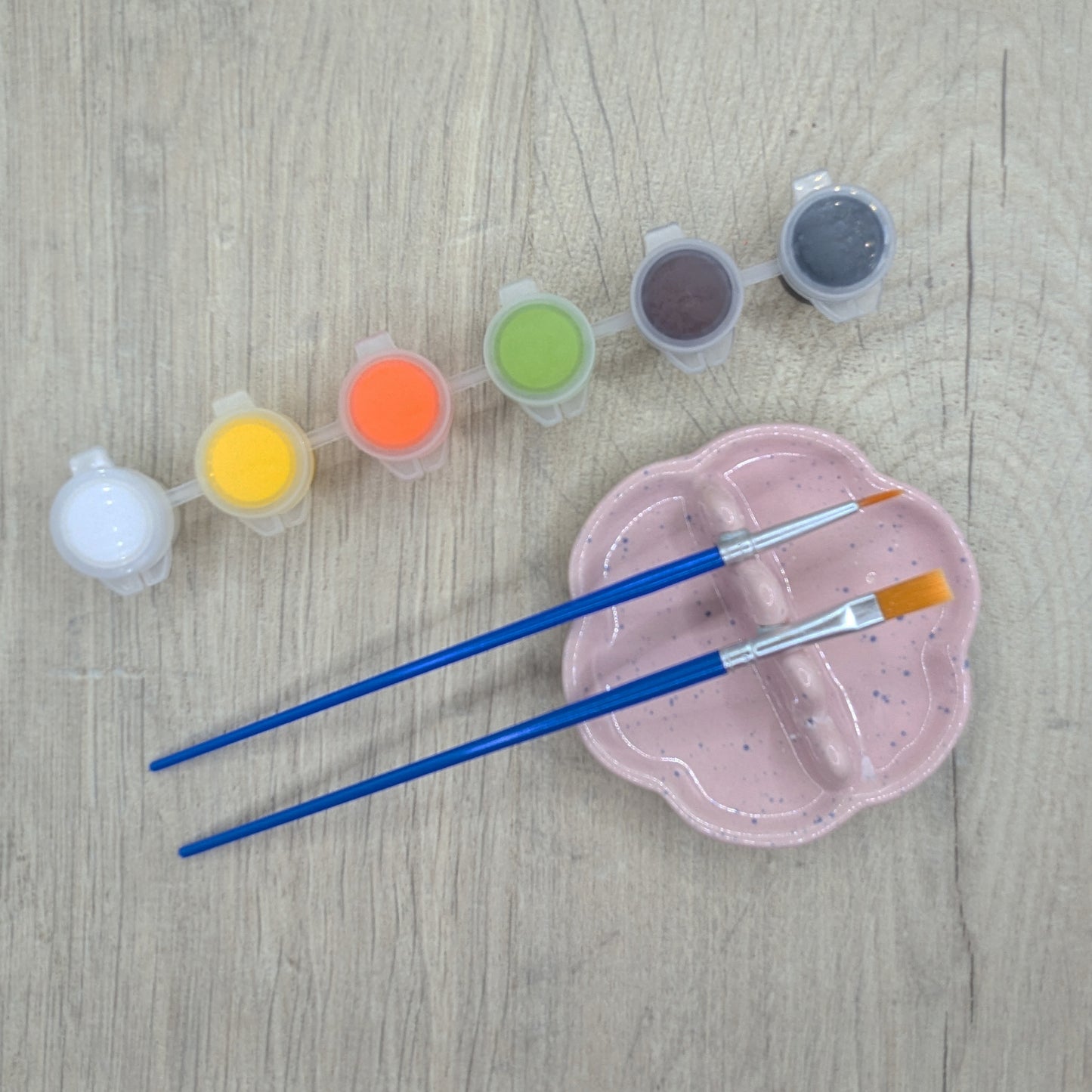 6 small pots of paint, white, yellow, orange, green, brown, black and two paint brushes