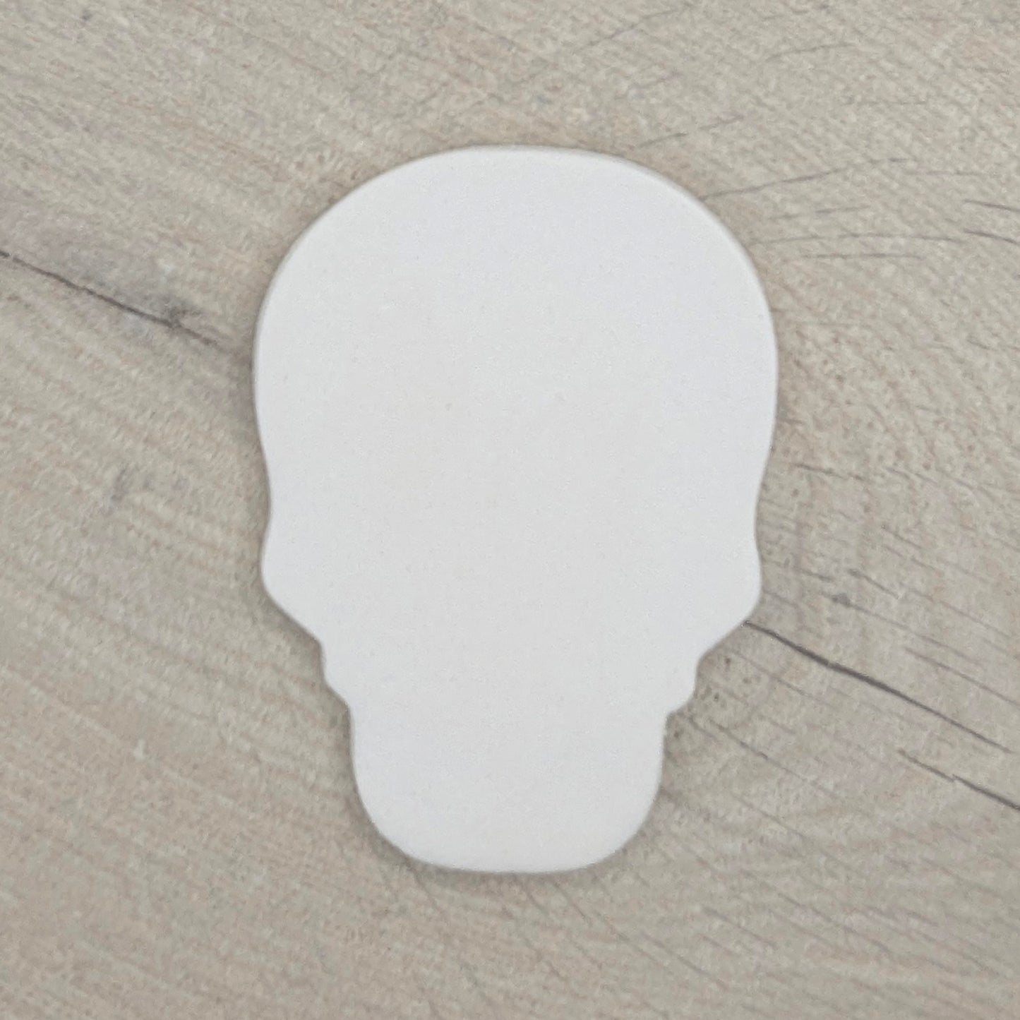 air dried clay decoration in the shape of a human skull on a wooden background