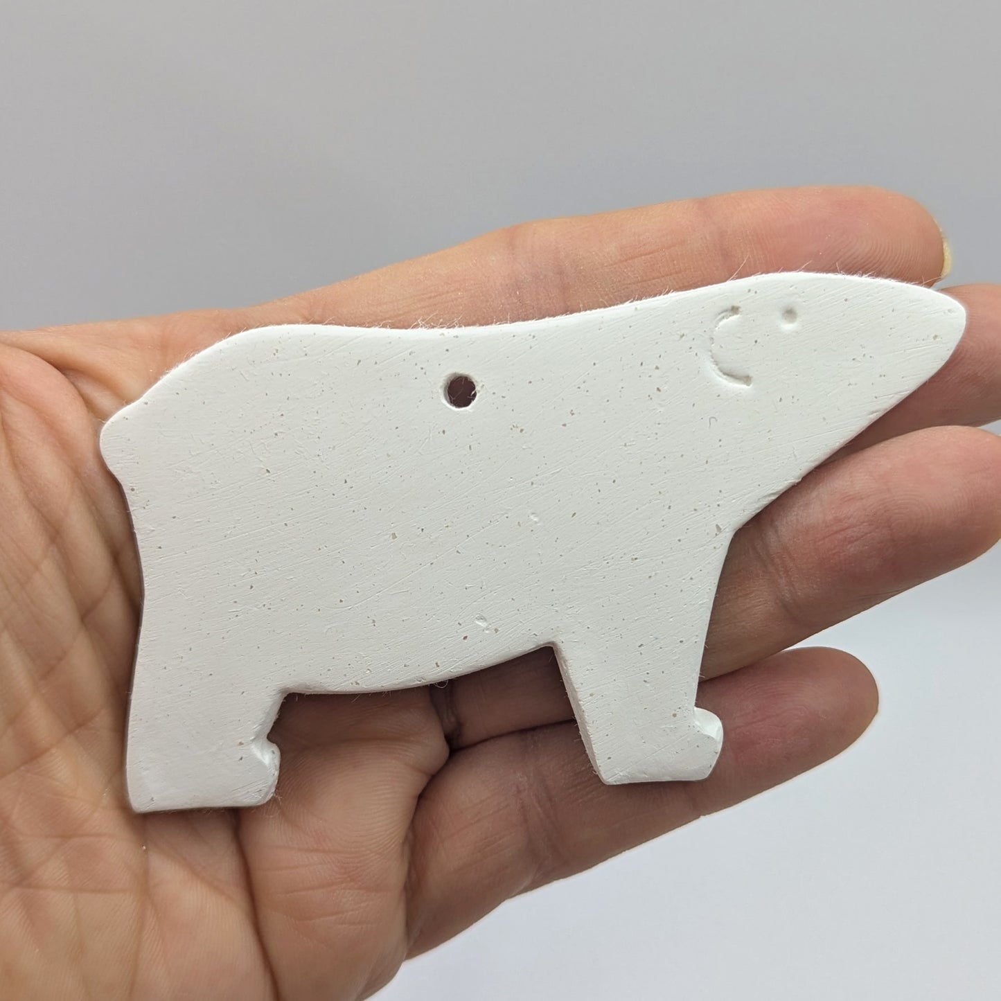 white air dried clay polar bear decoration, held in palm of hand, ear and eye stamped into the clay