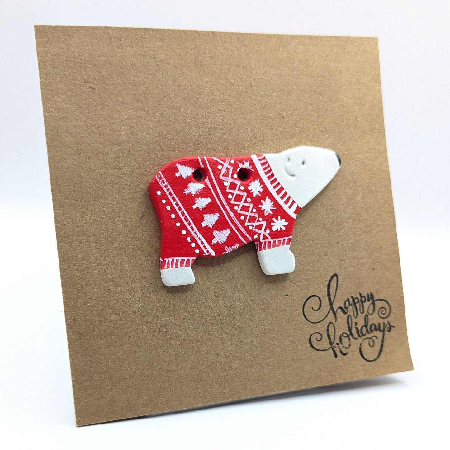 sample of a polar bear with a painted red and white xmas jumper on, displayed on a 'happy holidays' kraft card