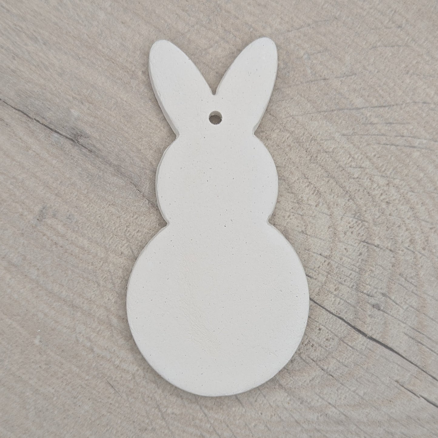 clay decoration in the shape of a rabbit, round body and head, made of air dried clay
