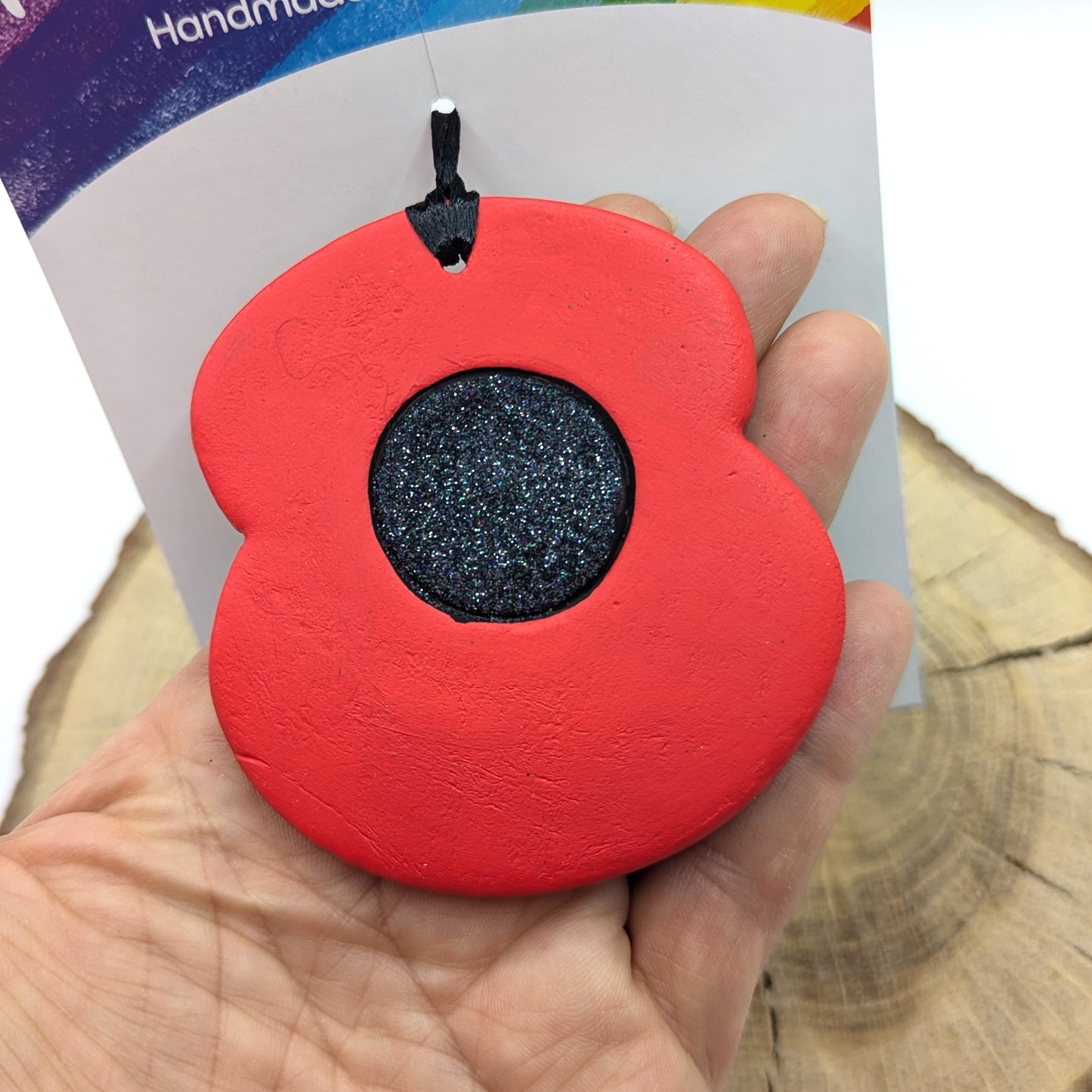 painted clay decoration in red and black with black glitter centre of poppy