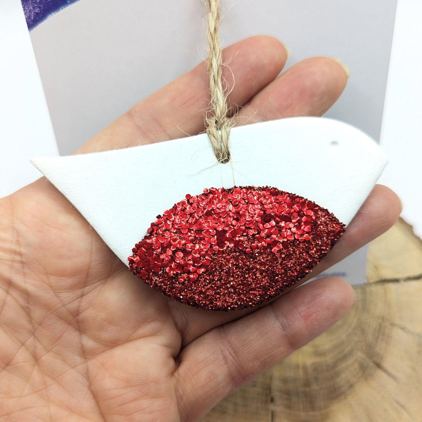 robin clay decoration with red glitter red breast, held in hand