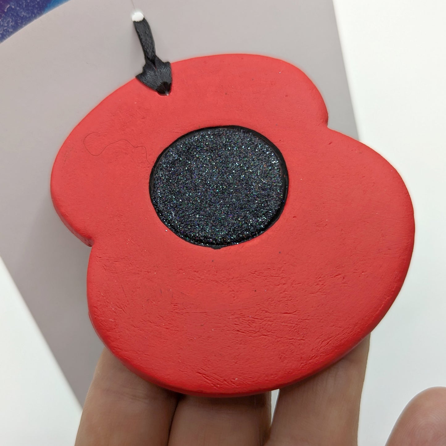 painted poppy clay decoration in red and black with black glitter poppy centre