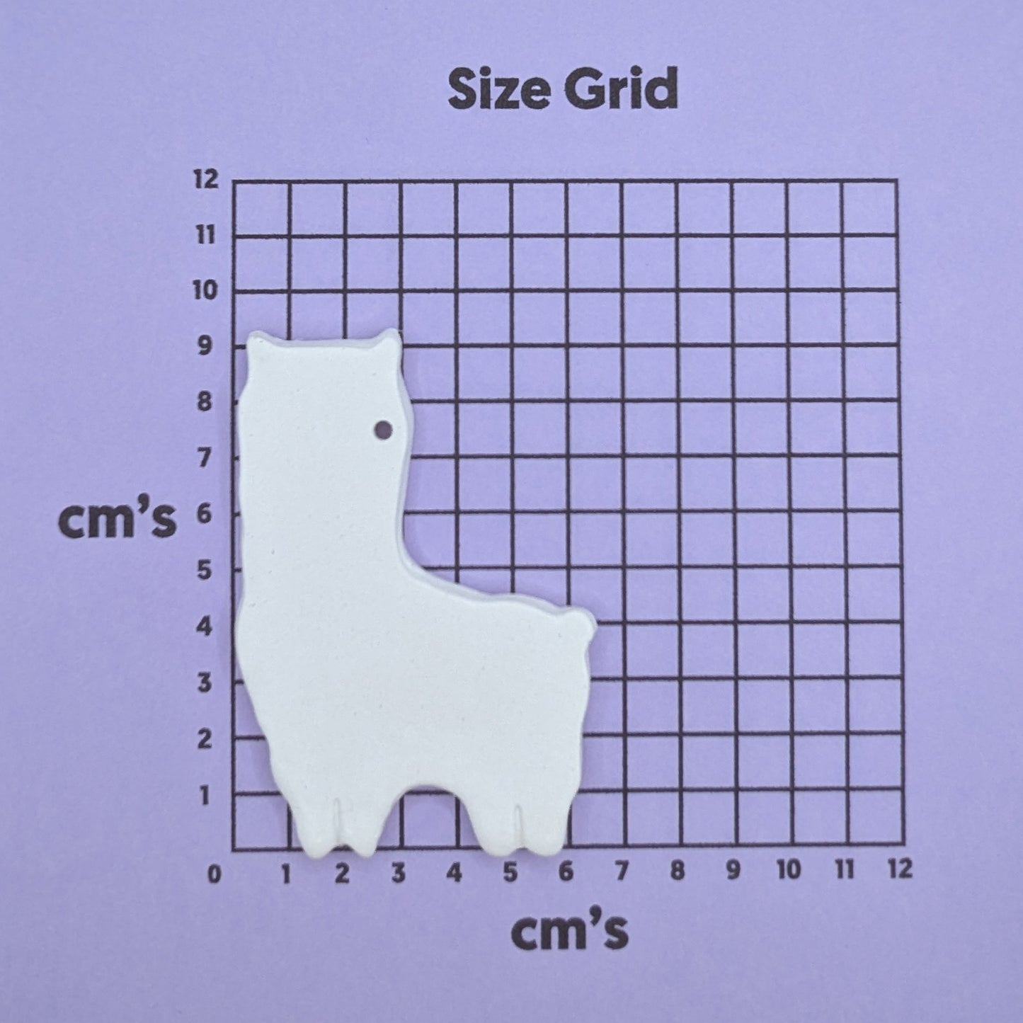 clay alpaca / llama decoration on a size grid with measurements in centimeters