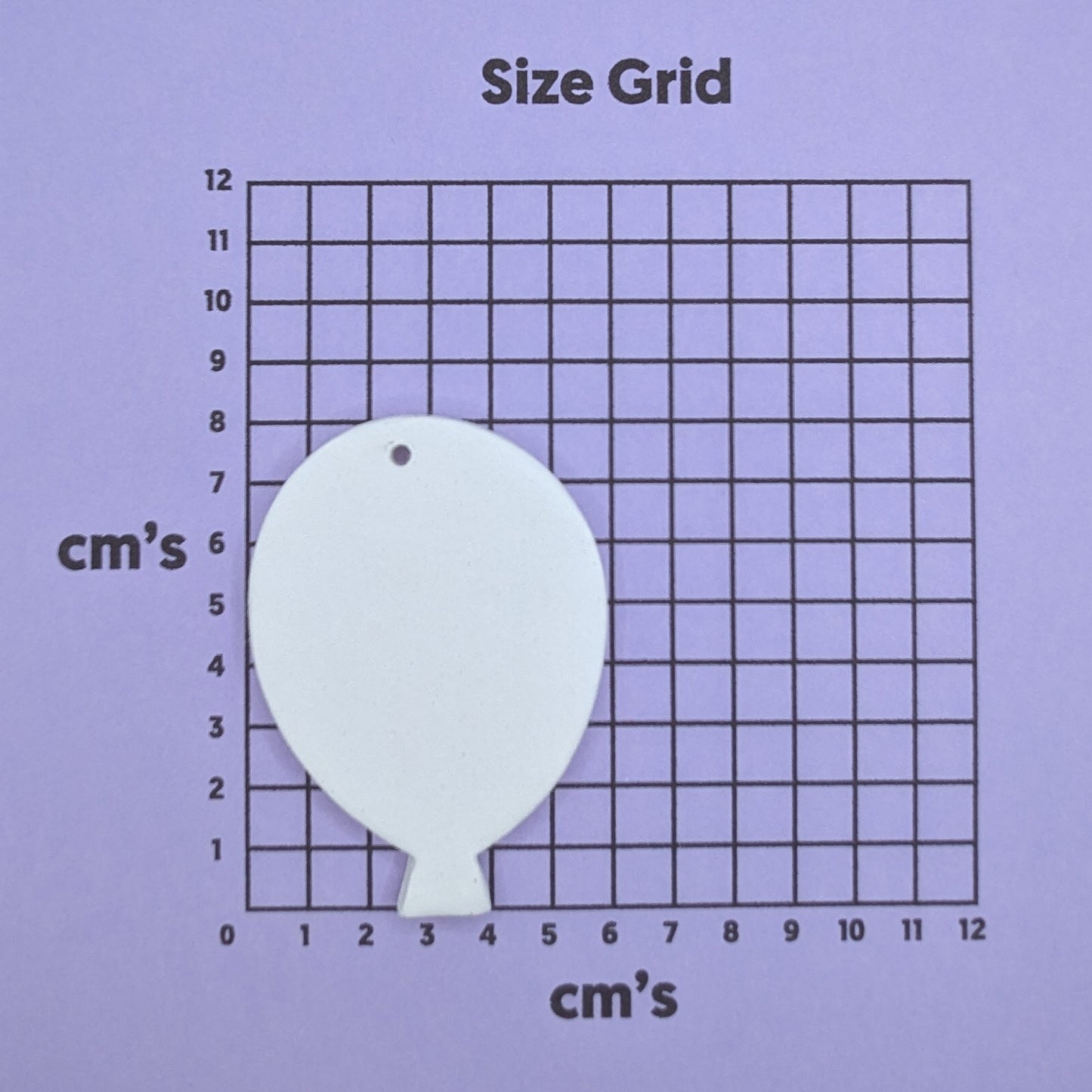 clay balloon decoration on a size grid with measurements in centimeters