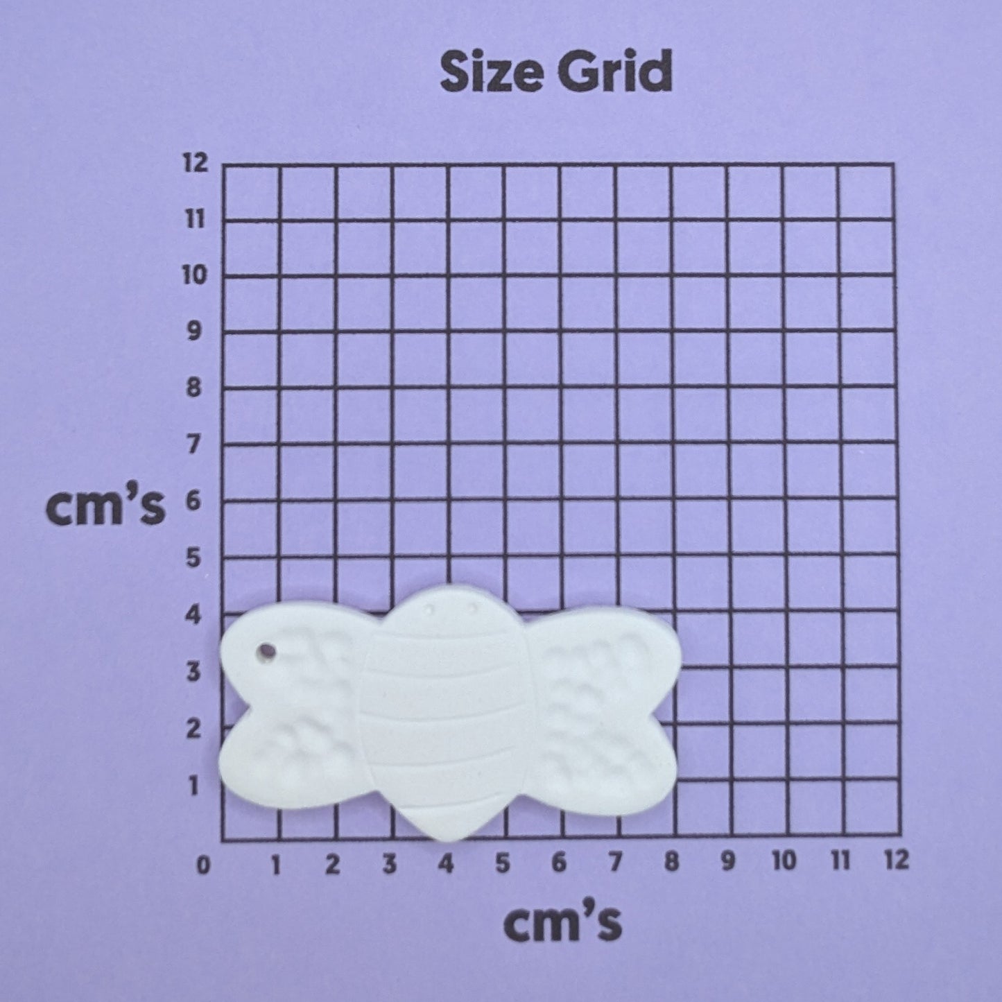 clay bumble bee decoration on a size grid with measurements in centimeters