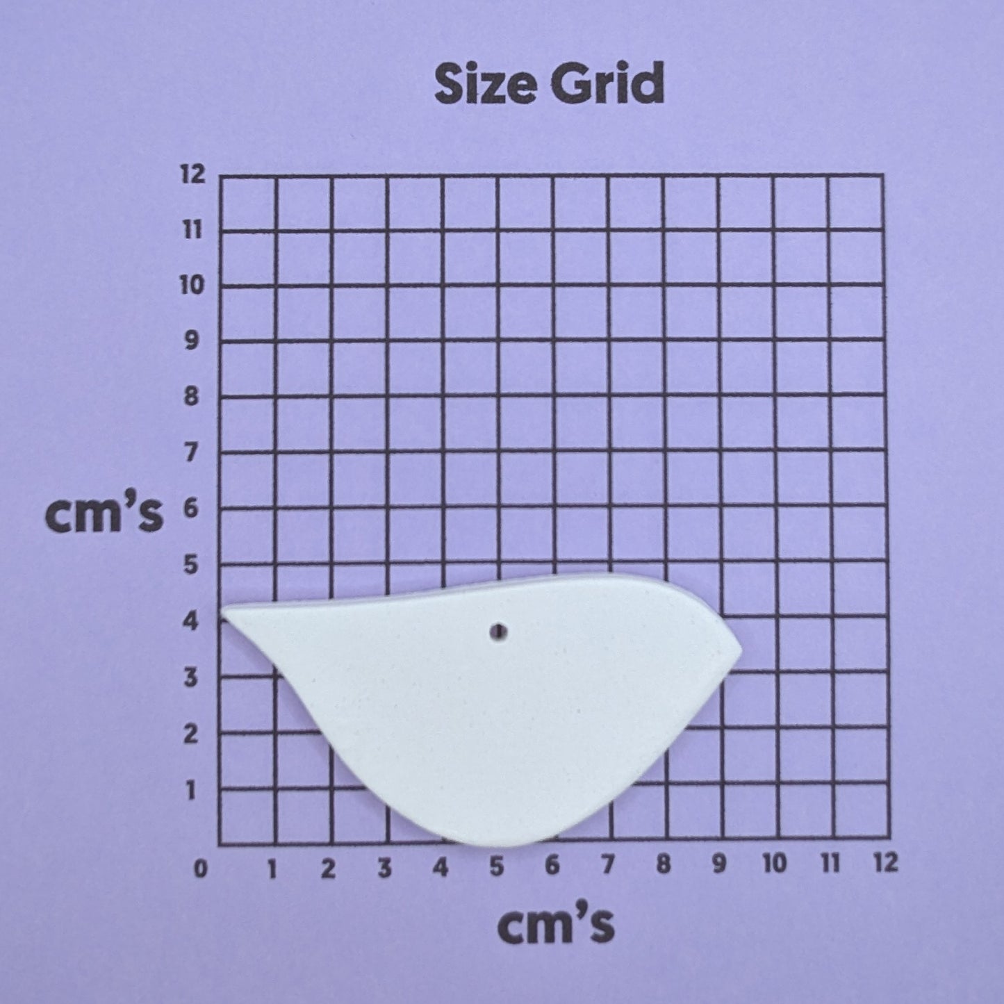clay robin decoration on a size grid with measurements in centimeters