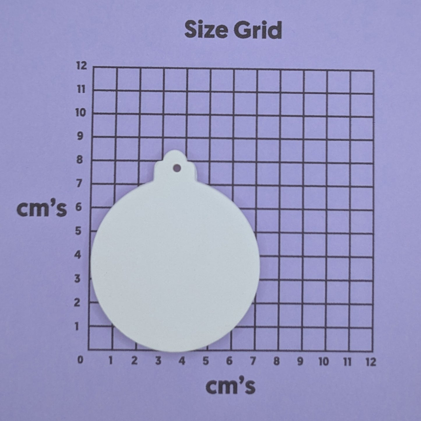 clay bauble decoration on a size grid with measurements in centimeters