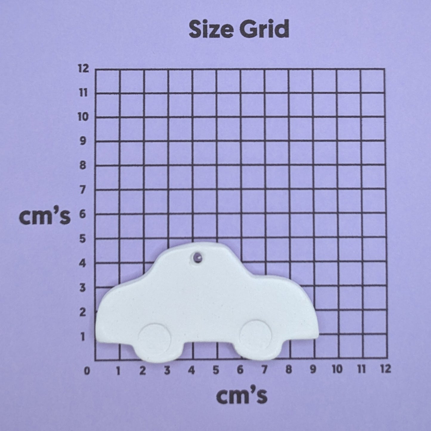 clay car decoration on a size grid with measurements in centimeters