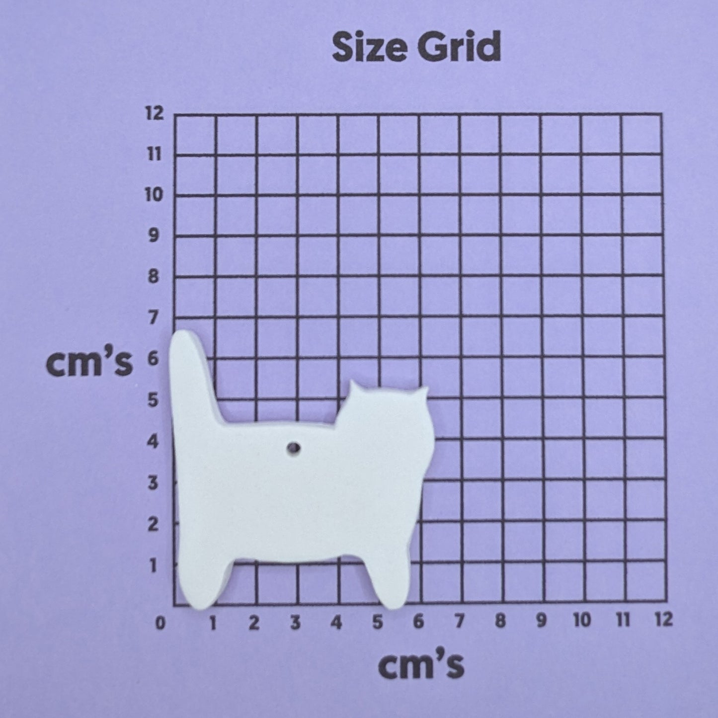 clay cat (side view) decoration on a size grid with measurements in centimeters
