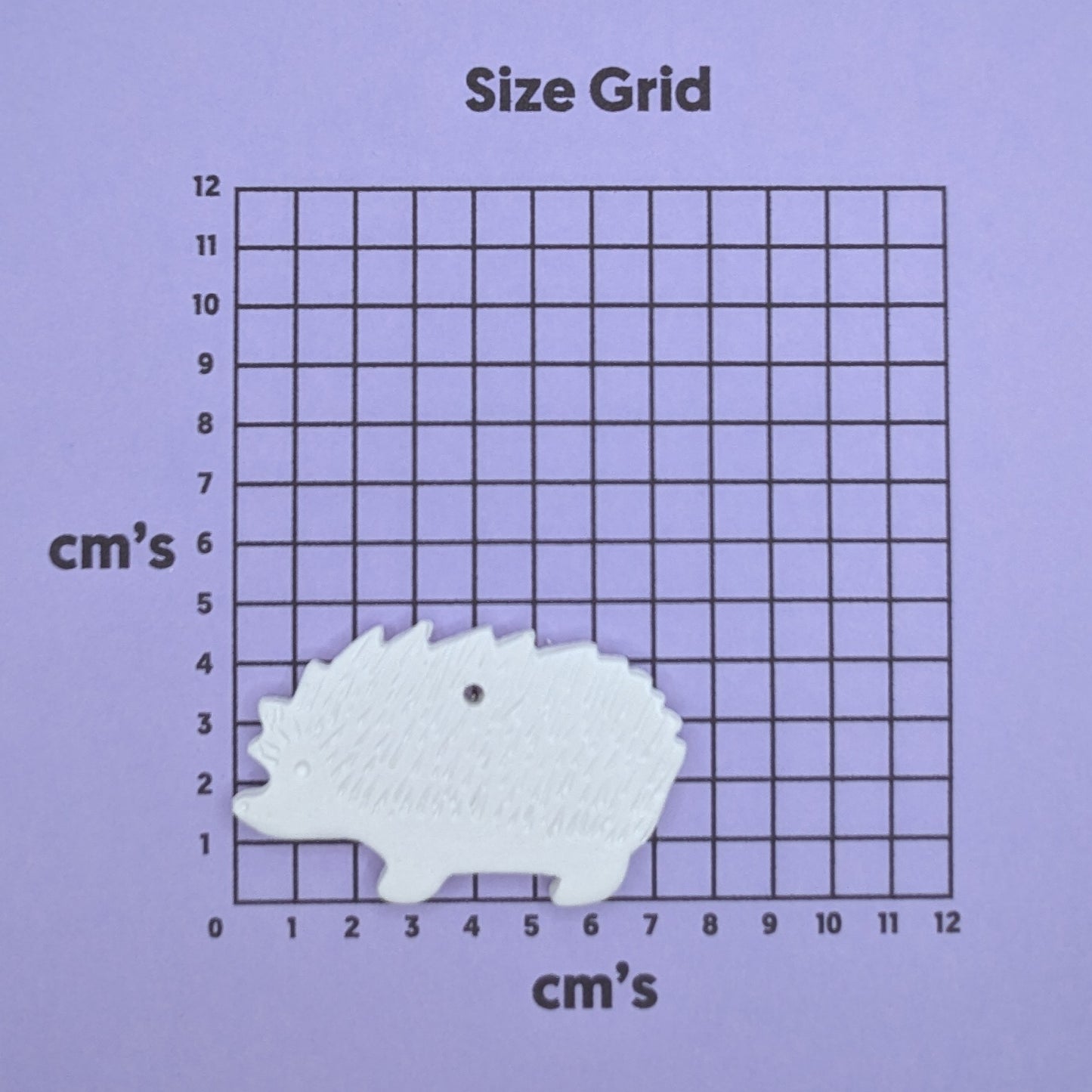 clay hedgehog decoration on a size grid with measurements in centimeters