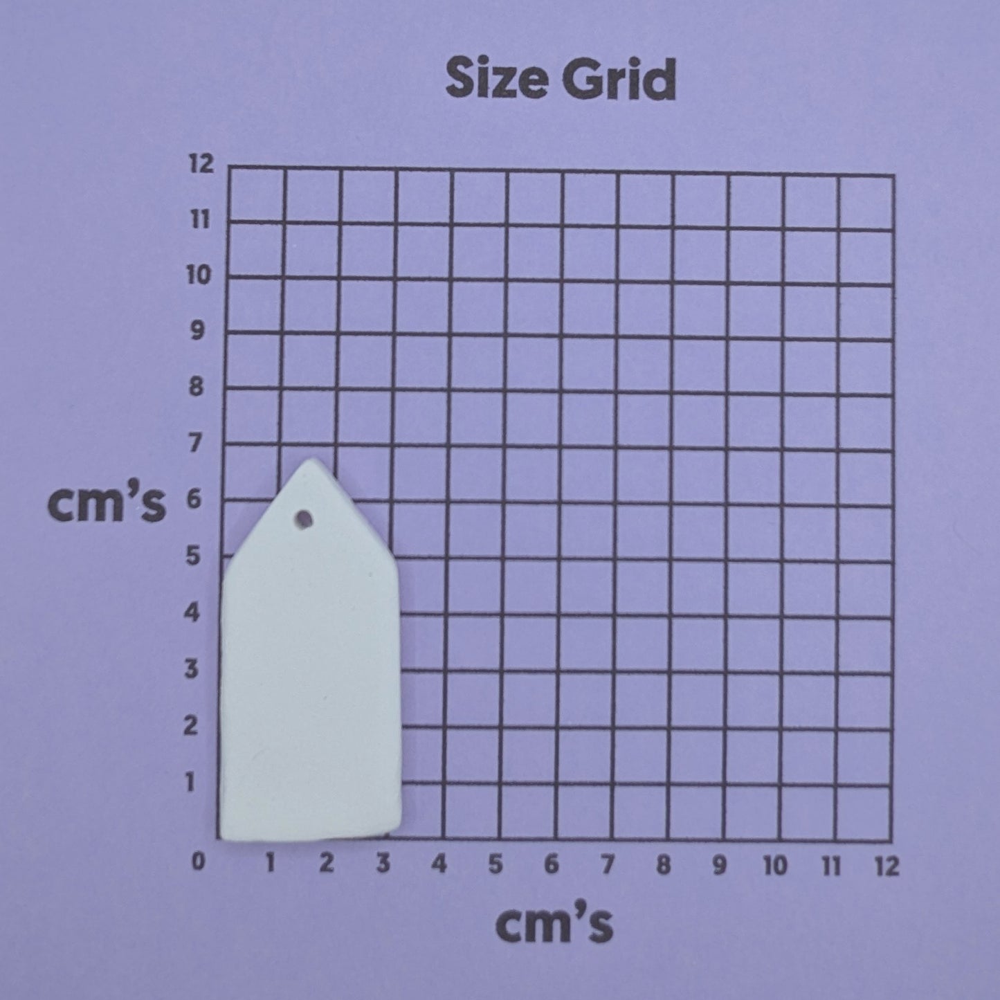 White house shaped decoration on a size grid with measurements in centimeters