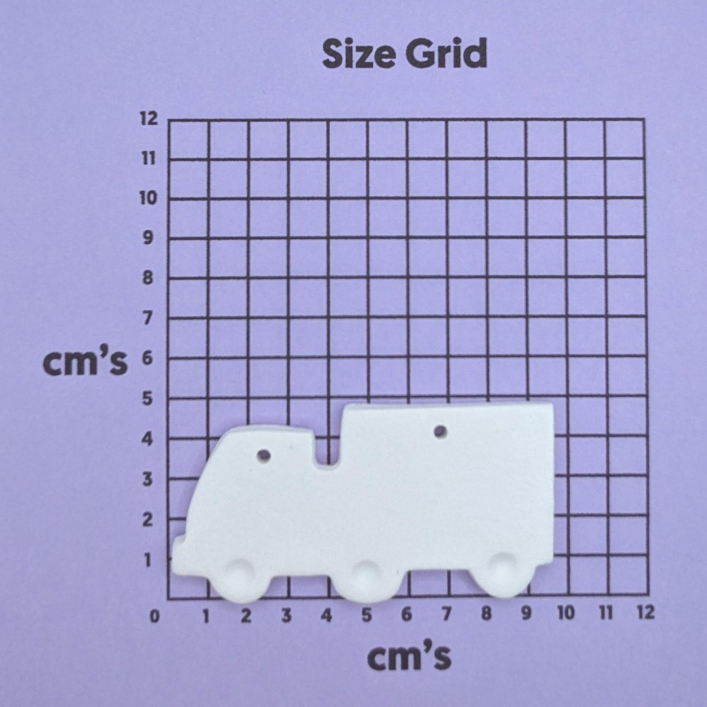clay lorry decoration on a size grid with measurements in centimeters