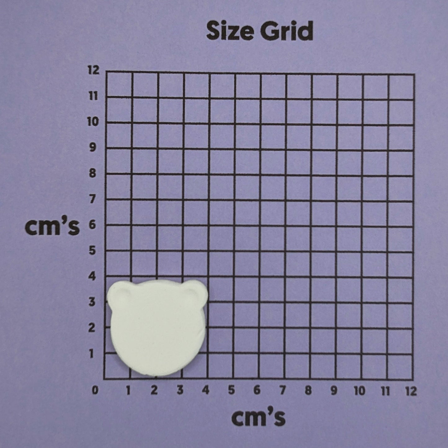 bear decoration on grid with measurements in centimeters on a purple background