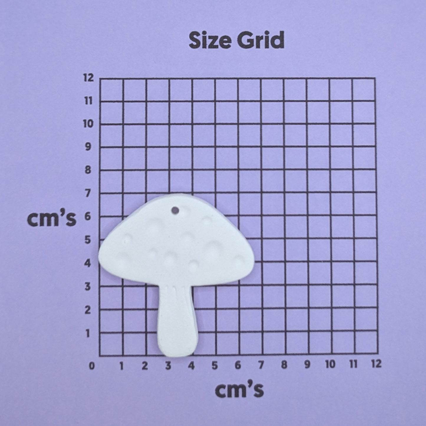 clay mushroom decoration on a size grid with measurements in centimeters