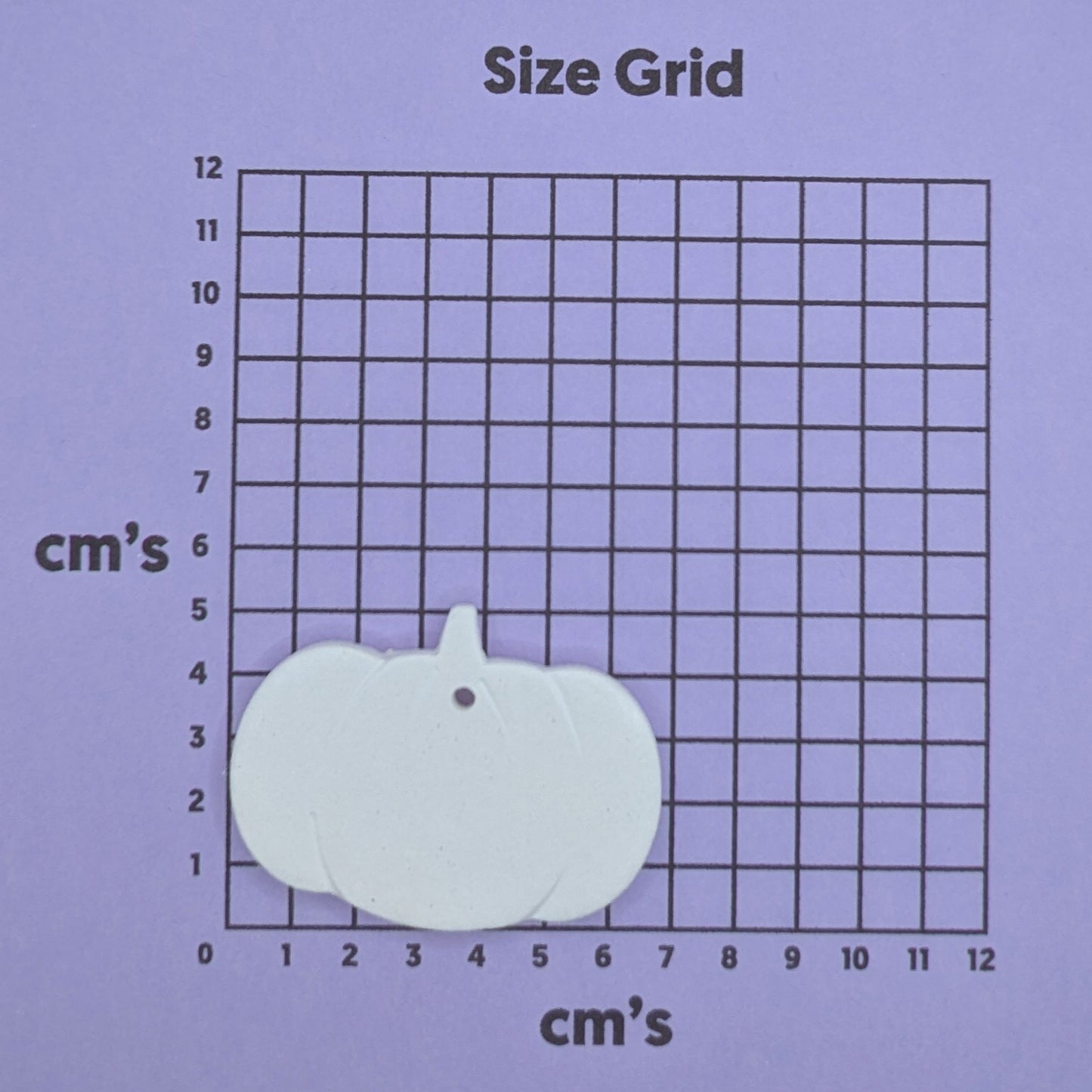 clay pumpkin decoration on a size grid with measurements in centimeters