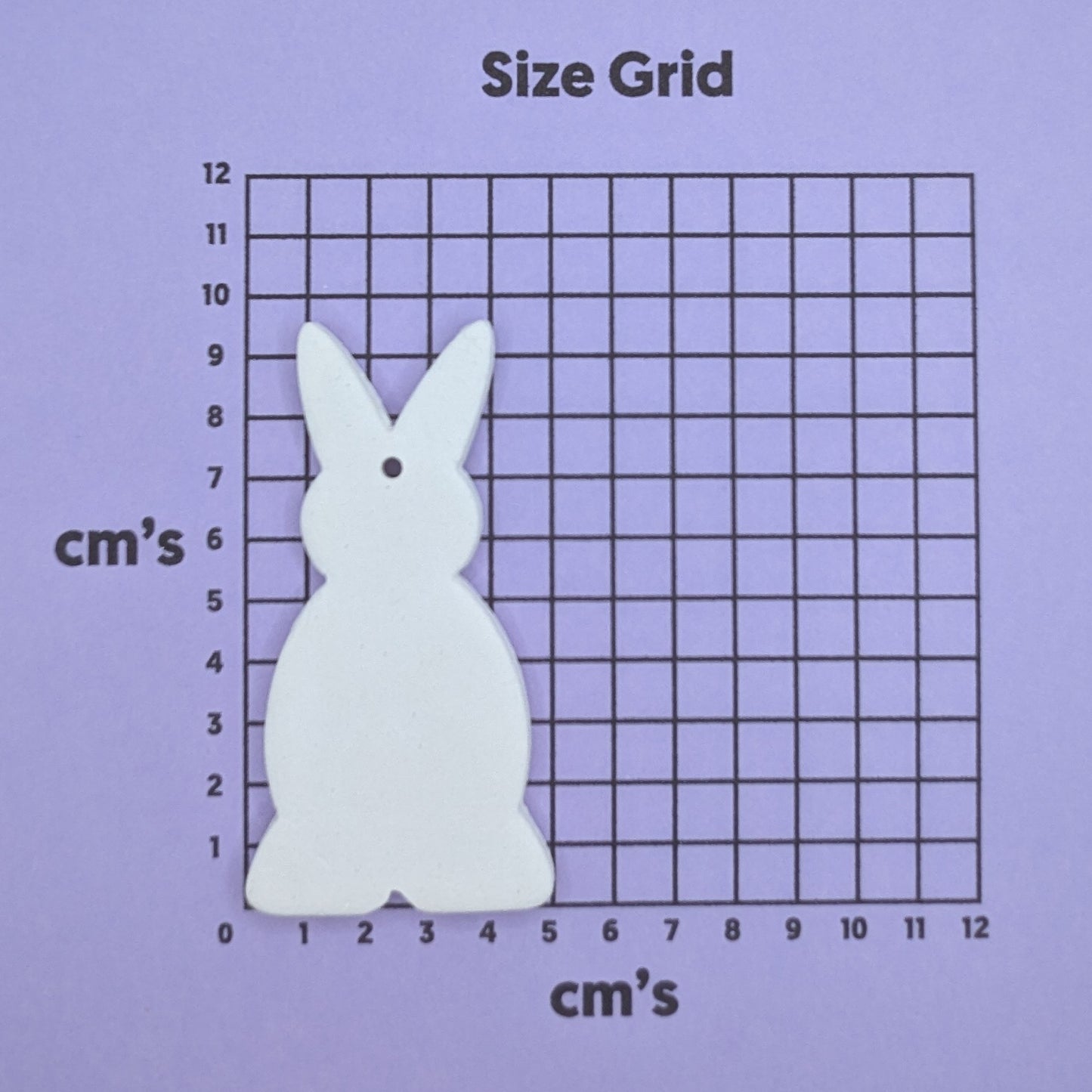 clay full body rabbit decoration on a size grid with measurements in centimeters
