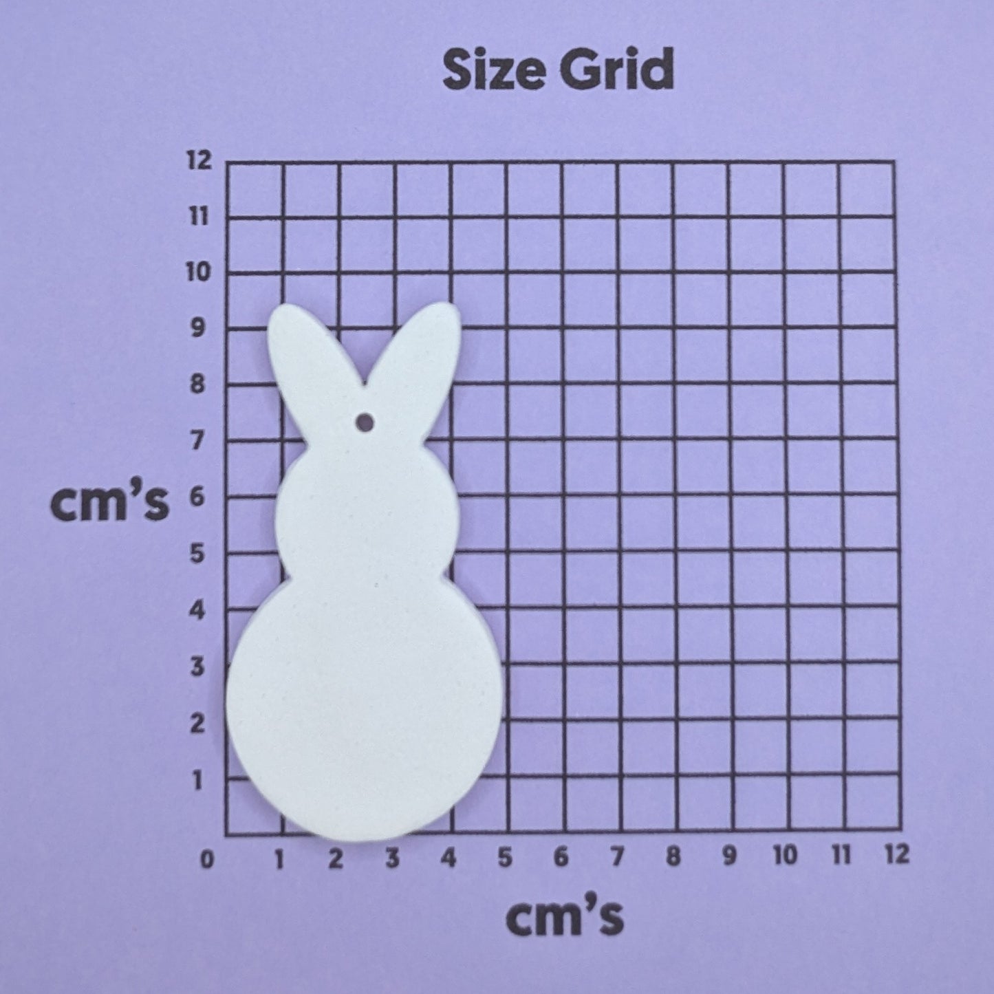 clay round body rabbit decoration on a size grid with measurements in centimeters
