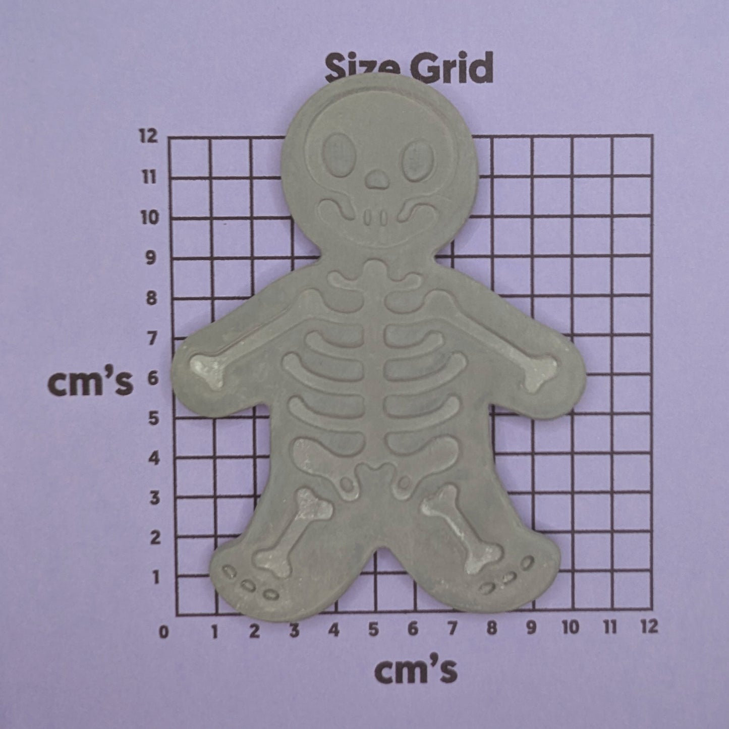grey skeleton clay decoration shown on size grid