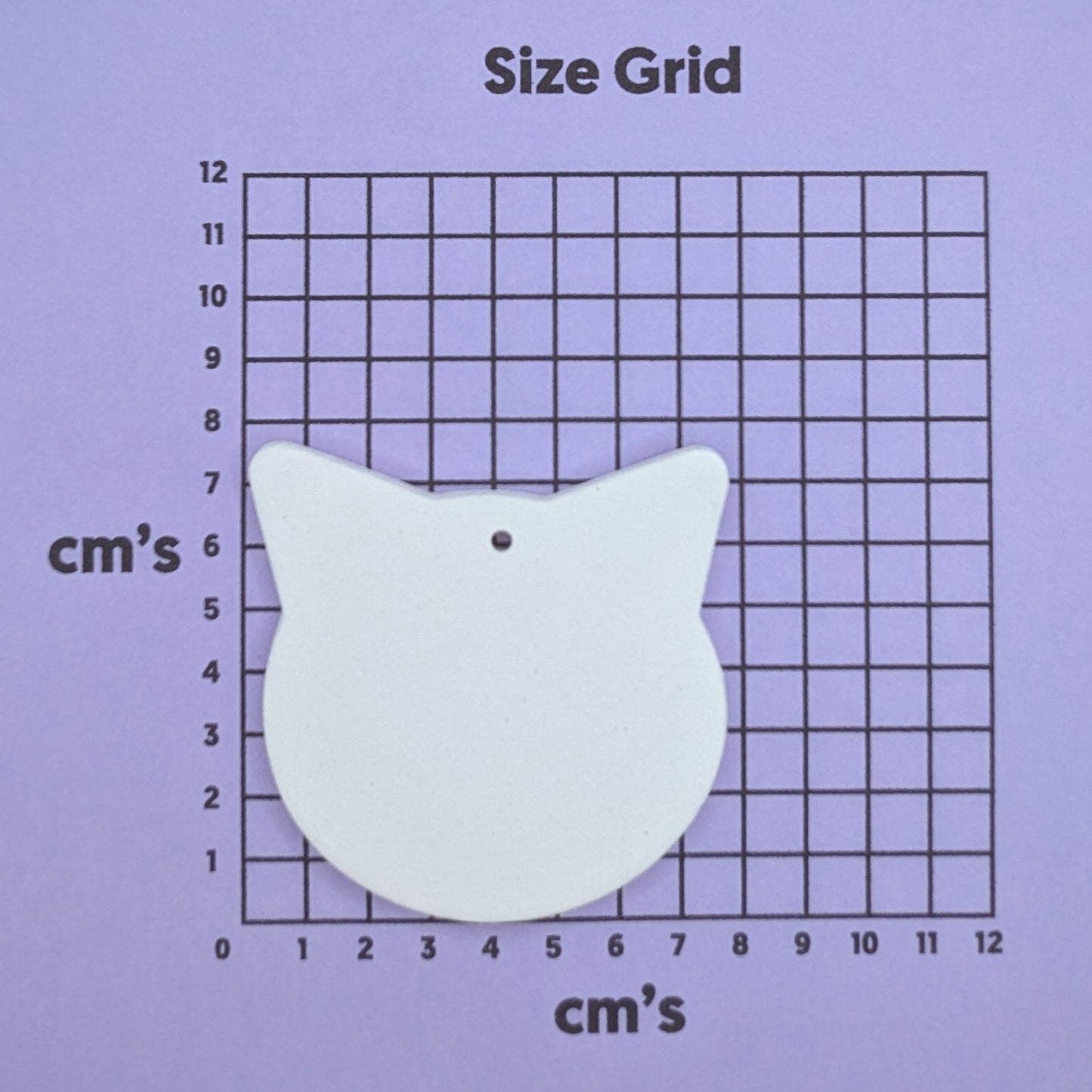 clay tiger shaped decoration on a size grid with measurements in centimeters