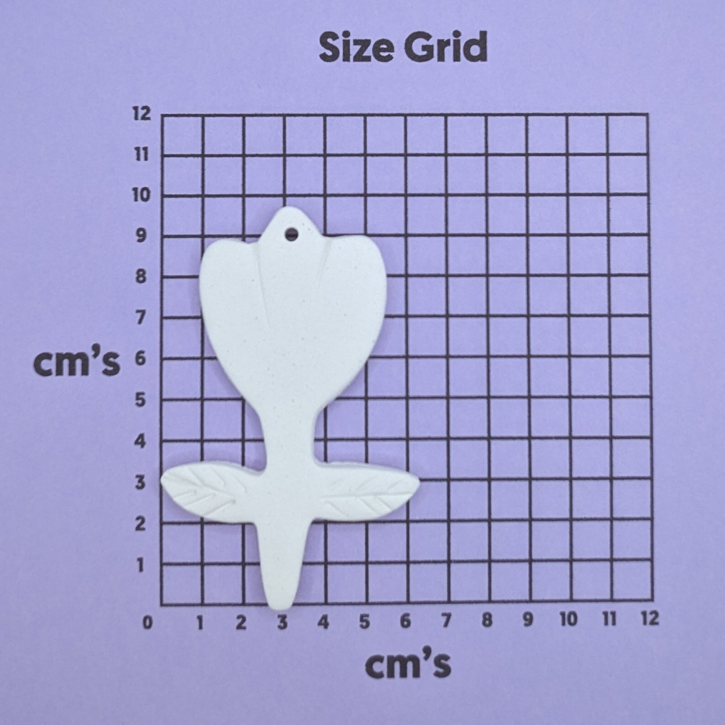 clay tulip decoration on a size grid with measurements in centimeters