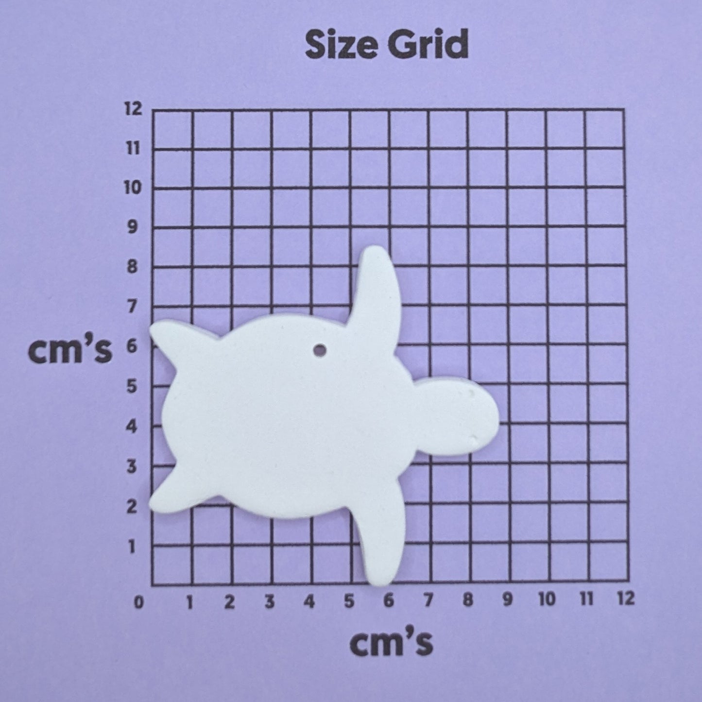 clay turtle decoration on a size grid with measurements in centimeters