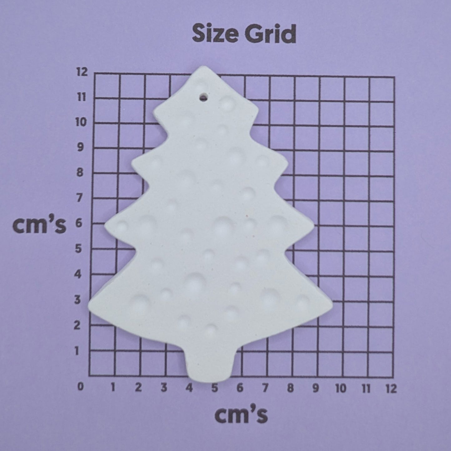 size chart with spotted christmas tree clay decoration on it to show size
