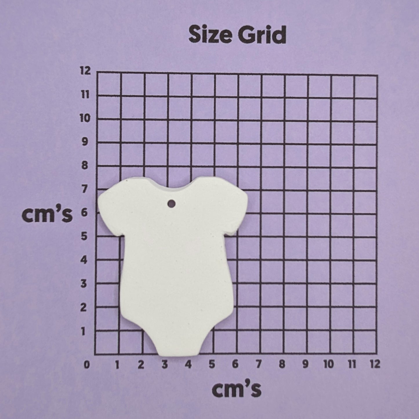 clay baby grow decoration on a size grid with measurements in centimeters