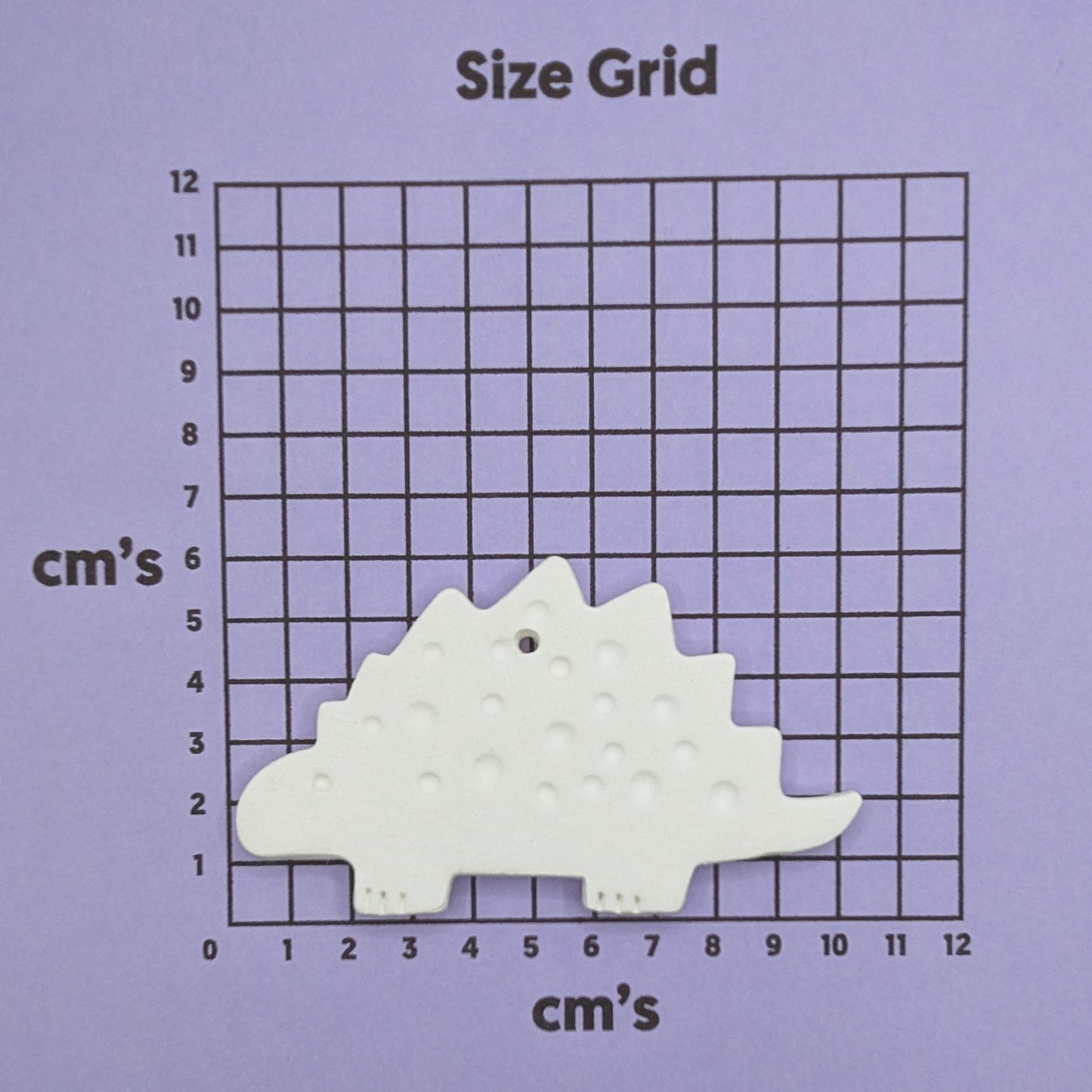 clay dinosaur decoration on a size grid with measurements in centimeters